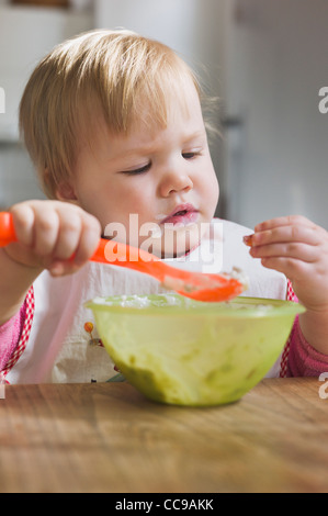 Baby Girl Eating from Bowl Stock Photo