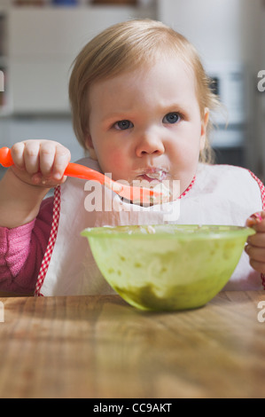 Baby Girl Eating from Bowl Stock Photo