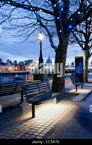 Queen's Walk, South Bank, London SE 1 with empty benches and street lighting with City Skyline including St Paul's Cathedral Stock Photo