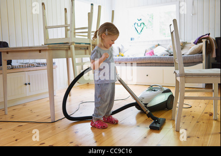 Young Girl Vacuuming Hardwood Floor, Sweden Stock Photo
