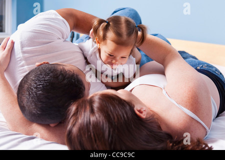 Family Lying on Bed Together Stock Photo