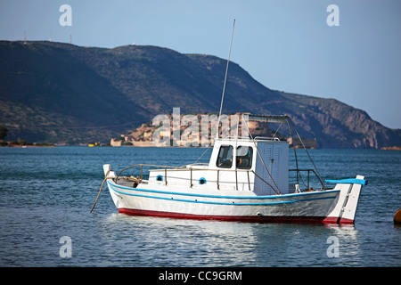 Old fishing boat on water. Evening. Spinalonga Island in background. Plaka, Crete Island, Greece. Stock Photo