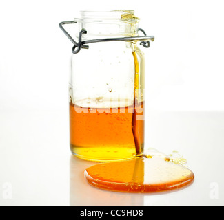 fresh Honey pouring from jar Stock Photo