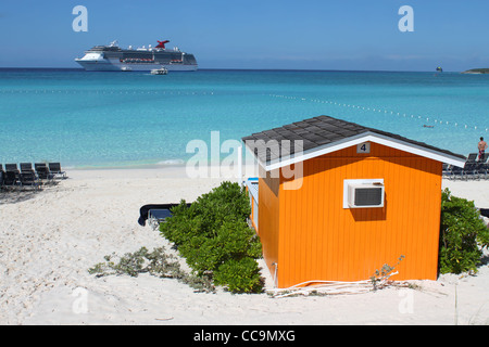 Colorful tropical cabana or shelter on the beach of Half Moon Cay in the Bahamas with cruise ship in the background Stock Photo