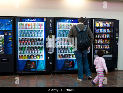 A man and child standing in front of soft drink vending machine - USA Stock Photo