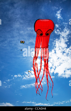 Bright red kite against a blue sky. Stock Photo