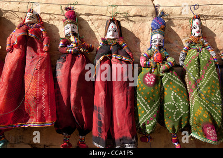 Puppet dolls on sale as souvenirs on a wall in Rajasthan, India. Stock Photo