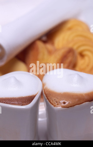 heart shaped espresso coffee cappuccino cups with assortment of pastry on background valentine day treat Stock Photo