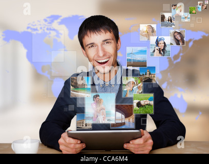 A technology man has images flying away from his modern tablet computer, He is at home. Designed poster for a communication, Stock Photo