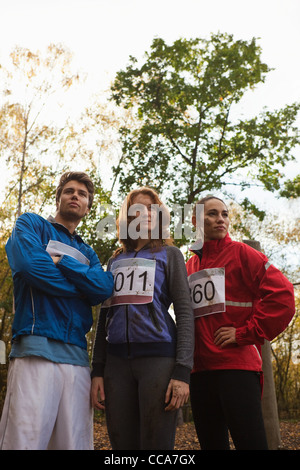 Young friends in sportswear standing together in forest Stock Photo