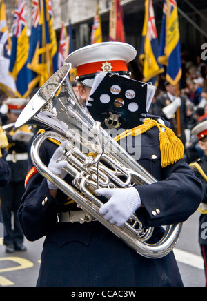Man playing a trombone in a marching band face hidden by music stand New years Day parade 2012 Whitehall London England Europe Stock Photo