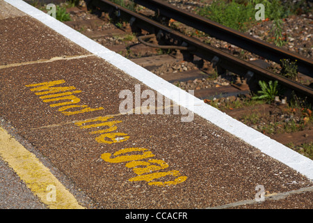 Mind the gap painted on platform at railway train station Stock Photo