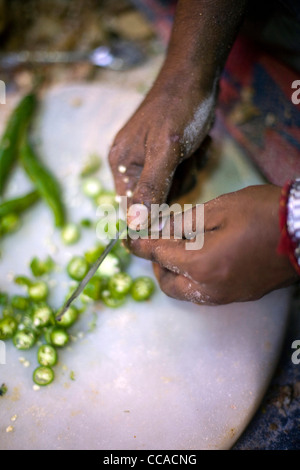Ram Billas cutting up chillies for the paratha at Parawthe Wala restaurant in Old Delhi, India Stock Photo