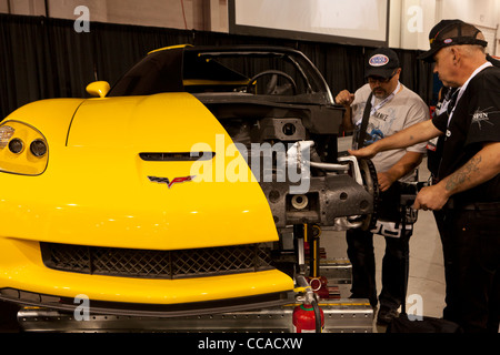Two mechanics inspecting a cutaway model of car Stock Photo