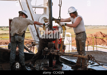 Roughnecks toil on an oil drilling rig in Oklahoma, USA Stock Photo