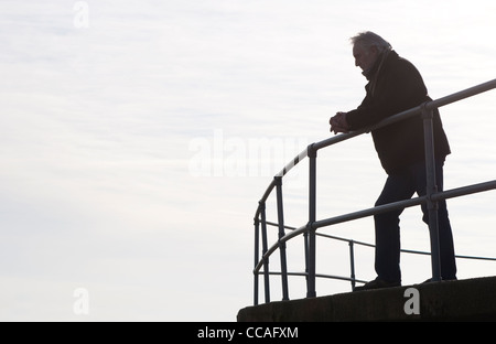 depressed senior male leaning on railings Stock Photo