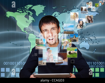 A technology man has images flying away from his modern tablet computer, He is at home. Designed poster for a communication, Stock Photo