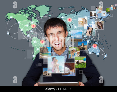 A technology man has images flying away from his modern tablet computer, He is at home. Designed poster for a communication, Stock Photo