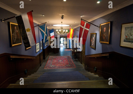 A row of hanging flags and paintings on the walls at the Master Builder's House Hotel where shipbuilder, Henry Adams resided with his family. Stock Photo