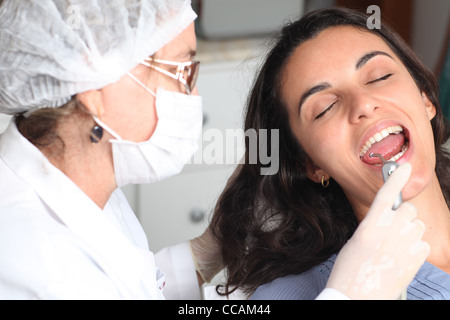 patient's open mouth during oral checkup at dentist with mirror near by Stock Photo