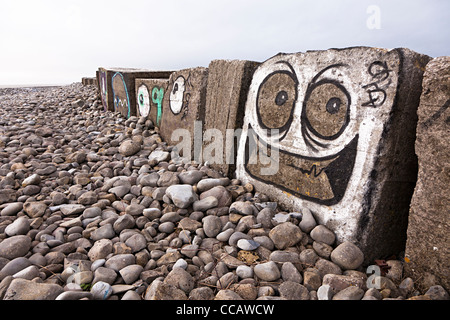 Face graffiti painted on Second World War coastal defences, Limpert Bay, South Wales, UK Stock Photo