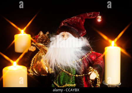 A Santa Claus figure with a big white beard with candles Stock Photo