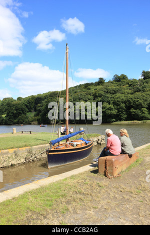 A sailing boat on the River Tamar at Cotehele Quay in Cornwall below Cotehele House. Stock Photo
