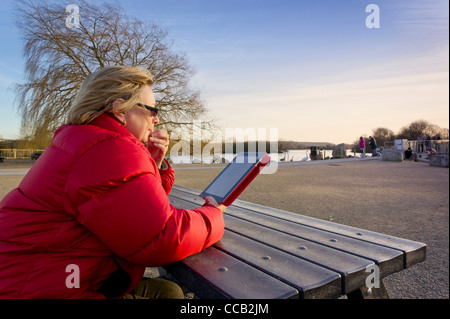 Woman using an Ipad 2 computer tablet outdoors Stock Photo