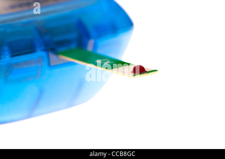 drop of blood on strip being tested for glucose level Stock Photo