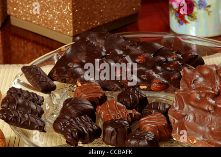 Assortment of chocolates on a glass plate with fancy coffee cup Stock Photo