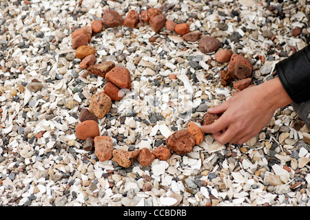 young man making a heart out of stones Stock Photo