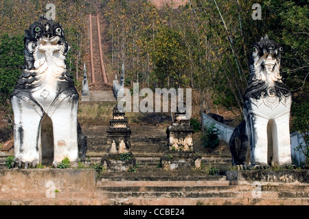 The stairways leading to Wat Phra Doi Kong Mu Buddhist temple is flanked by two large lion statues in Mae Hong Son, Thailand. Stock Photo