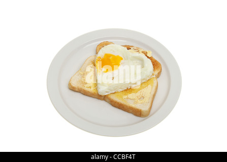 Heart shaped fried egg on buttered toast on a plate isolated against white Stock Photo