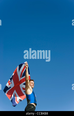 Male athlete holding up British flag Stock Photo