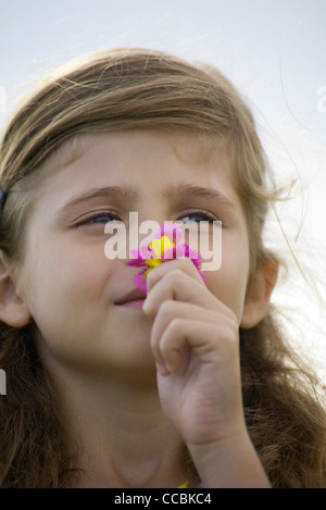 Portrait of a girl smelling a wildflower Stock Photo - Alamy