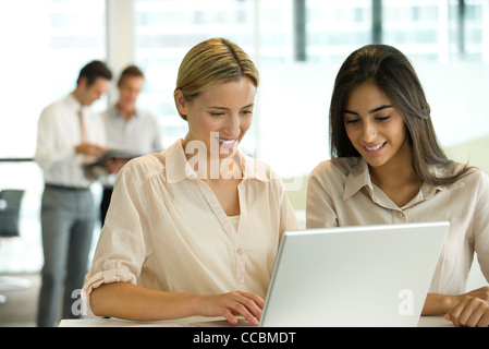 Female colleagues working together on laptop computer Stock Photo