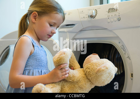 Little girl playing with teddy bear Stock Photo