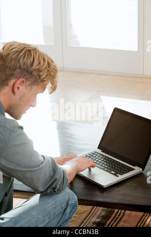 Man using laptop computer at home Stock Photo