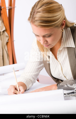 Female architect attractive working on a blueprint sketches in office Stock Photo