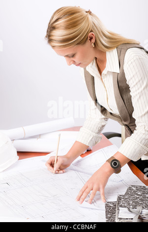 Female architect attractive working on a blueprint sketches in office Stock Photo