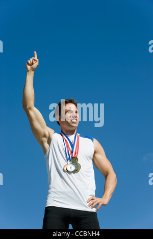 Male athlete with hand raised in victory Stock Photo