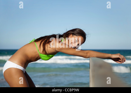 Woman in bikini stretching at the beach, portrait Stock Photo