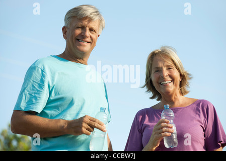 Senior couple holding bottles of water, portrait Stock Photo