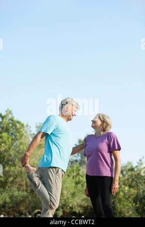 Senior couple stretching together outdoors Stock Photo