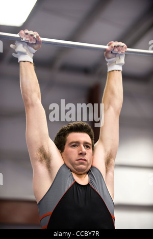 Muscular man hanging on bar and performing calisthenics pull up ...