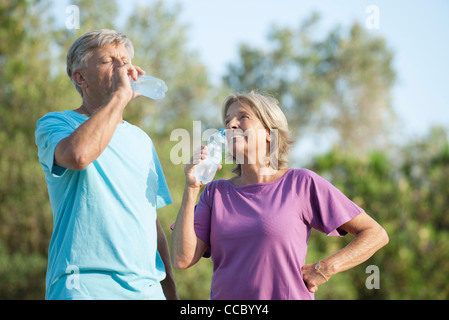 Senior couple drinking bottled water outdoors Stock Photo