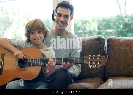 Father teaching son how to play guitar Stock Photo