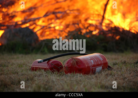 two fire extinguisher with flames from a fire burning Stock Photo