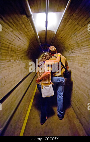 A young couple hug as they tour an inspection tunnel at Hoover Dam on the Colorado River. Stock Photo