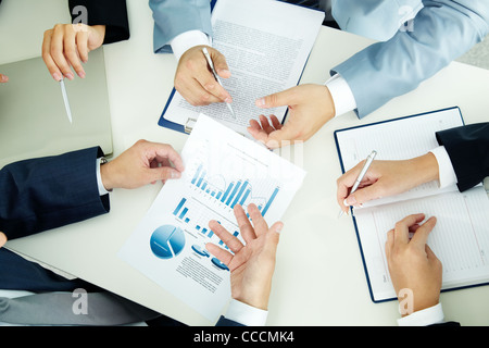 Image of busiess group discussing business documents at meeting Stock Photo